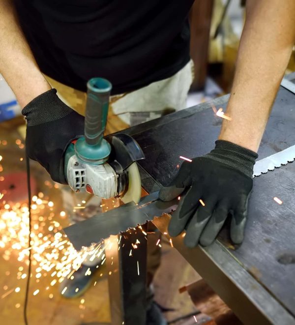 Metalwork craftsman cutting metal with grinder tools. Worker man working in workshop